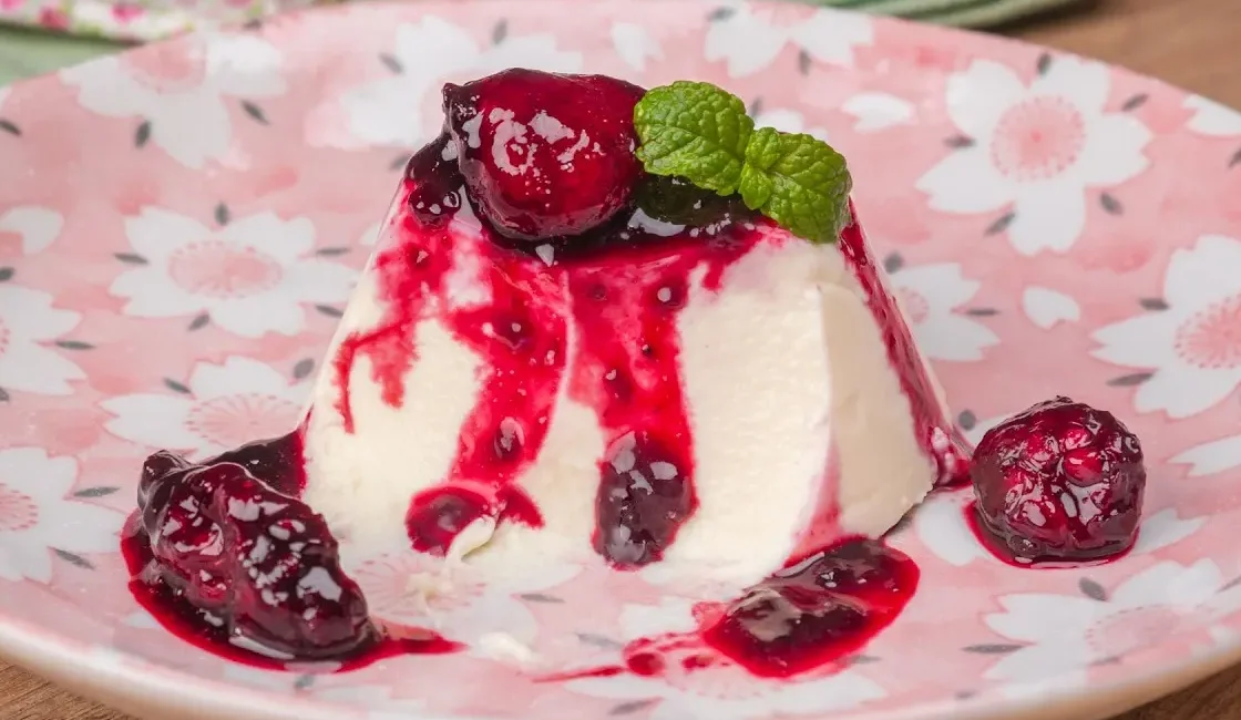 A panacota (panna cotta, o “creme cozido” italiano) é a sobremesa perfeita para quando você quer algo sofisticado com esforço mínimo. Aqui, a base é só creme de leite + leite + açúcar + gelatina — nada de gema de ovo — e o segredo está no ponto do cozimento: aquecer sem ferver, para manter a textura de seda. A cobertura de frutas vermelhas entra com acidez linda e cor vibrante. Fica pronta em minutos, gela e vai à mesa com cara de restaurante. Ingredientes da Panacota de Frutas Vermelhas (sem gema) Base da panacota (6 a 8 porções) 400 ml de creme de leite fresco (ou nata culinária) 200 ml de leite integral ⅓ a ½ xícara (chá) de açúcar (ajuste ao seu paladar; eu uso ½ para contraste com a calda) 1 colher (chá) de extrato de baunilha (ou ½ fava) 1 envelope (12 g) de gelatina incolor sem sabor 5 colheres (sopa) de água para hidratar a gelatina 1 pitada de sal Calda de frutas vermelhas 2 xícaras (chá) de frutas vermelhas mistas (morango, framboesa, amora, mirtilo — podem ser frescas ou congeladas) ¼ a ⅓ xícara (chá) de açúcar Suco de ½ limão 2 a 3 colheres (sopa) de água (se usar frutas frescas, pode nem precisar) Para finalizar (opcional) Frutinhas inteiras para decorar Raspas finas de limão-siciliano Folhinhas de hortelã Rende 6 taças generosas ou 8 porções menores. Sobre os itens e o tempo de preparo Utensílios: panela de fundo grosso, fouet, tigela pequena para a gelatina, peneira (opcional para a calda), forminhas individuais de silicone/vidro/metal ou uma forma única de 18–20 cm. Tempo: 10 minutos no fogão + 4–6 horas de geladeira (ideal montar na véspera). Dica da Chef: para desenformar fácil, unte levemente as forminhas com uma gotinha de óleo neutro e passe papel-toalha para tirar o excesso — fica só um “filme”. Modo de preparo da receita Hidrate a gelatina Misture a gelatina com a água e deixe absorver por 5 minutos. Reserve. Aqueça a base Na panela, junte creme de leite, leite, açúcar, baunilha e uma pitadinha de sal. Aqueça em fogo baixo, mexendo, até quase ferver — quando surgirem bolhinhas nas bordas e o creme estiver bem quente, desligue. Importante: não ferver, para não talhar e não perder a textura sedosa. Incorpore a gelatina Com o fogo desligado, adicione a gelatina hidratada e mexa até dissolver por completo. Se usar fava, retire a casca agora. Coe (opcional) e porcione Se quiser textura ultra lisa, coe a mistura. Distribua em taças ou forminhas. Deixe amornar, cubra e leve à geladeira por 4–6 horas (ou até firmar com balanço suave). Faça a calda Leve as frutas com o açúcar, limão e água ao fogo médio. Cozinhe por 4–6 minutos, até que as frutas liberem suco e a calda engrosse levemente. Deixe esfriar completamente. Se preferir lisa, passe por peneira e volte parte das frutas por cima para textura. Finalize e sirva Desenforme mergulhando rapidamente o fundo da forminha em água morna e soltando as bordas com delicadeza. Cubra com a calda fria, decore e sirva. Dica da Chef: se quiser camada dupla, coloque metade da panacota nas taças, gele 20 minutos, faça uma fina camada de calda fria, gele mais 10 minutos e complete com o restante do creme. Visual de festa. O resultado Panacota branca, brilhante e macia, que se dobra na colher. A calda rubi das frutas corta a doçura com acidez elegante. É uma sobremesa leve na boca, fotogênica e com sabor limpo — perfeita para fechar refeições caprichadas. Variações deliciosas Panacota de iogurte: troque 150 ml do creme por iogurte grego natural na mistura já morna (após a gelatina). Fica mais leve e levemente tangy. Cítrica: infusione tirinhas de casca de laranja/limão no leite quente, retire antes de gelar e finalize com calda de laranja reduzida. Baunilha real: ferva rapidamente a fava com o leite, repouse 10 minutos, raspe as sementes e siga a receita. Com queijo mascarpone: substitua 100 ml do creme por mascarpone e bata com o creme morno antes de gelar para textura mais rica. Cobertura mista: metade frutas vermelhas, metade coulis de maracujá para contraste amarelo-rubi de tirar foto. Versão Fitness/Light (sem açúcar, mais proteína) Base: 300 ml de creme de leite fresco + 300 ml de leite desnatado (ou bebida vegetal), 2 a 3 colheres (sopa) de eritritol/xilitol, baunilha e 12 g de gelatina incolor hidratada. Toque proteico: incorpore ½ pote de iogurte grego à base morna, depois da gelatina dissolvida. Calda: frutas vermelhas cozidas com 1–2 colheres (sopa) de adoçante culinário e suco de limão. Fica estável, com doçura moderada e ótima saciedade. Sem lactose: use creme vegetal culinário + leite de amêndoas/aveia. Vegana: substitua a gelatina por ágar-ágar (1 colher de chá rasa dissolvida em 150 ml de água; ferva 2 minutos e incorpore ao creme vegetal quente). Ajuste a quantidade para manter a textura tremidinha. Como ganhar dinheiro com essa receita A Panacota de Frutas Vermelhas tem visual premium e execução rápida, perfeita para delivery e eventos. Por que vende bem Baixo custo de produção e alto valor percebido. Estável na geladeira, ideal para montar com antecedência. Apresentação versátil: taças, potes com tampa, mini porções. Formatos e preços sugeridos (ajuste à sua região) Taça 150–180 g: R$ 14–20 Mini taça 90–120 g (coquetel): R$ 8–12 Pote com tampa 200 g: R$ 18–24 Bandeja festa (porções individuais): preço sob encomenda Dicas da Chef Use potes transparentes para valorizar o contraste branco/rubi. Padronize pesagem para margens consistentes. Transporte gelada e entregue com colher e tampa firmes. Rotule com sabor, validade (até 3 dias refrigerada) e possíveis alérgenos. Sugestões de acompanhamento Biscoitinho amanteigado ou tuile crocante Café espresso ou chá preto Vinho moscatel ou espumante brut para ocasiões especiais Quando servir essa delícia Almoços de domingo e jantares românticos Mesas de sobremesa em eventos e casamentos Dias quentes, pela leveza e frescor Cardápio “sem forno” e sobremesas de véspera Dúvidas comuns e truques da Chef Ficou dura demais. Excesso de gelatina. Meça com precisão; a textura correta é tremidinha, nunca firme como gelatina comum. Talhou/coalhou. Ferveu. Aqueça só até quase ferver, mexendo sempre. Não desenforma. Aqueça as laterais rapidamente com água morna e passe uma faca fina nas bordas. Calda muito doce. Corrija com mais limão ou um gole de água; a panacota pede calda levemente ácida. Um toque de humor Existe uma ciência oculta chamada “teste da tremidinha”. Você abre a geladeira, dá um leve chacoalhar e, se a panacota balança como nuvem em dia de brisa, está no ponto. Se não balança, alguém provou antes do tempo. Conclusão A Panacota de Frutas Vermelhas (sem gema de ovo) é a sobremesa-curinga: poucos ingredientes, técnica simples e resultado elegante. Com base cremosa, baunilha perfumada e calda rubi fresca, ela fecha qualquer refeição com leveza e classe. Faça hoje, gele e sirva amanhã com aquele “uau” garantido.